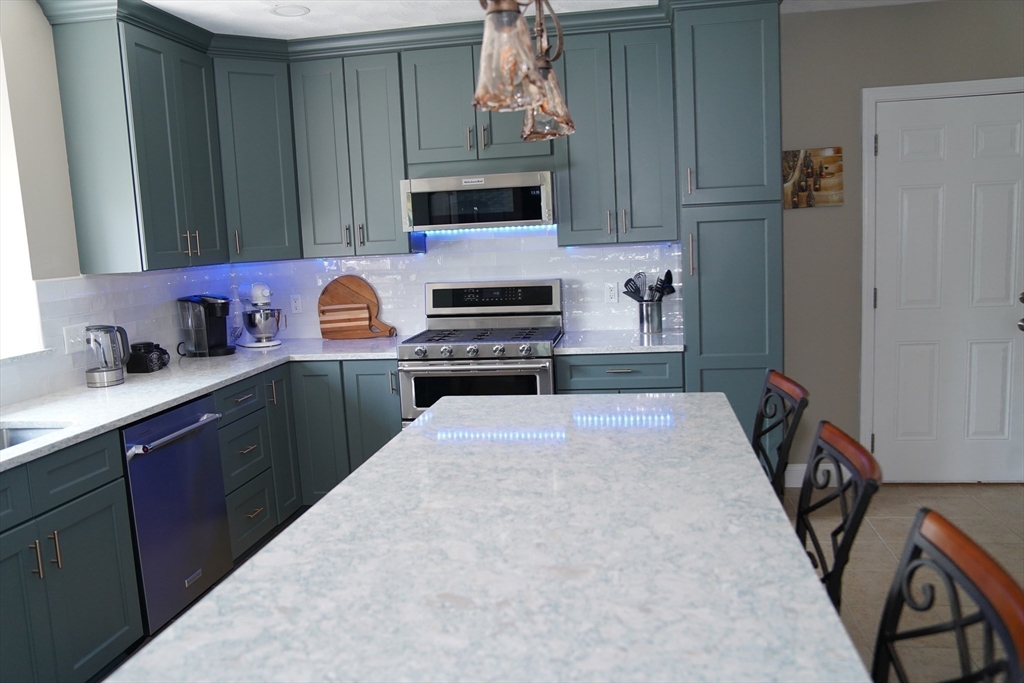 7 Turtle Hill Road, Unit B Ayer, MA 01432 - Photo 13 of 42 a kitchen with granite countertop a stove a sink and a microwave