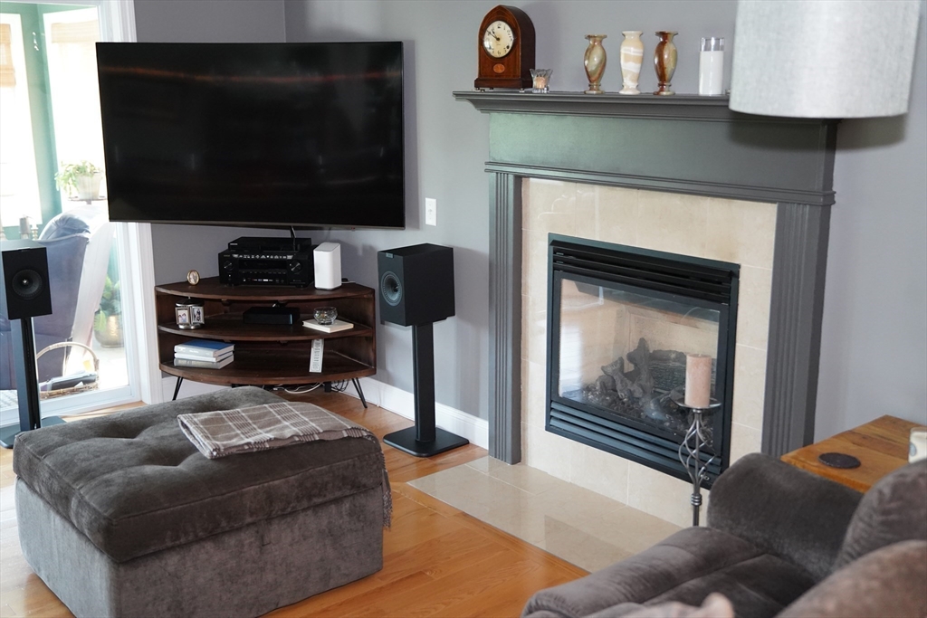 7 Turtle Hill Road, Unit B Ayer, MA 01432 - Photo 19 of 42 a living room with furniture a flat screen tv and a fireplace