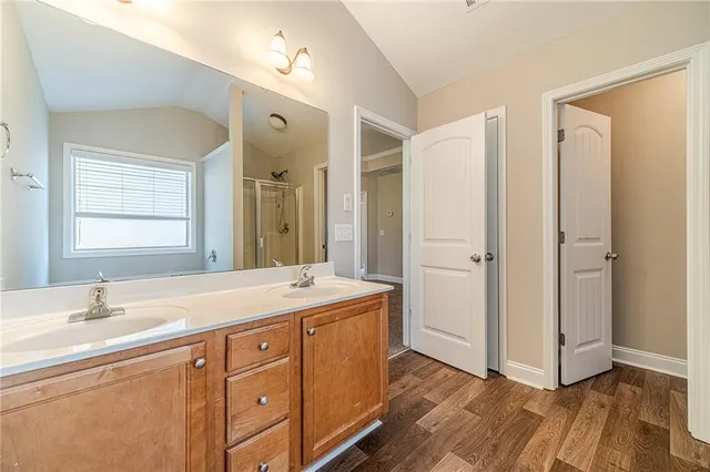 a spacious bathroom with a double vanity sink a mirror and a shower