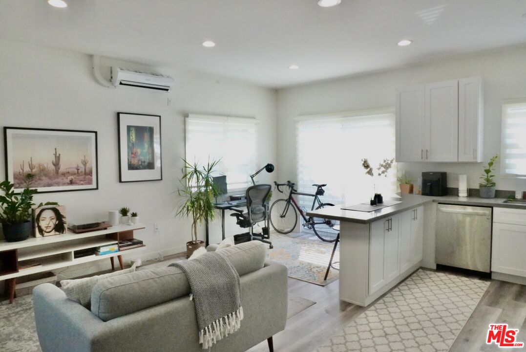 1157 South Point View Street Los Angeles, CA 90035 - Photo 5 of 15 a very nice looking living room with stainless steel appliances granite countertop furniture a sink a rug and a window