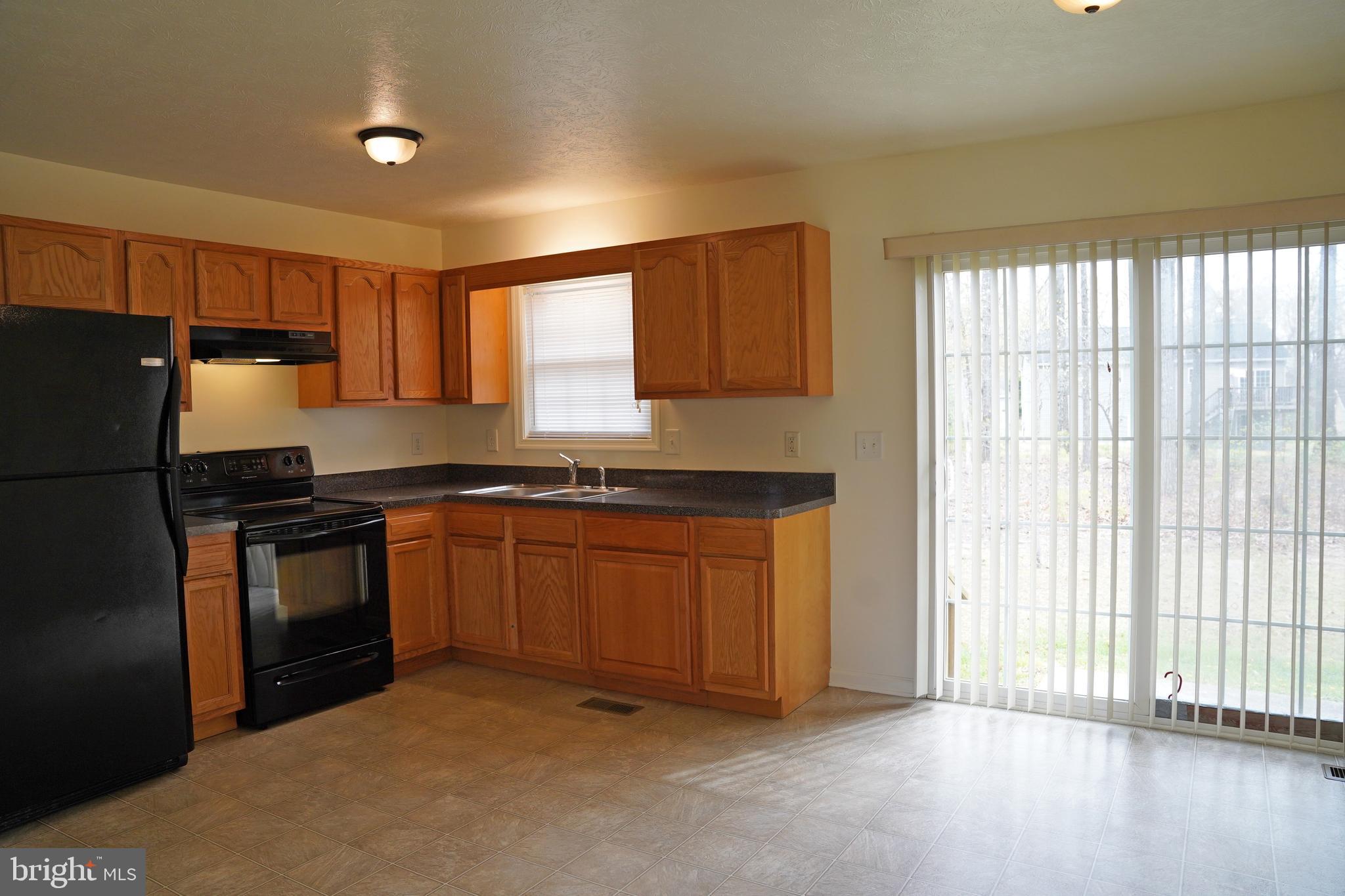 122 Sinker Drive Inwood, WV 25428 - Photo 5 of 28 a kitchen with granite countertop a refrigerator and a sink