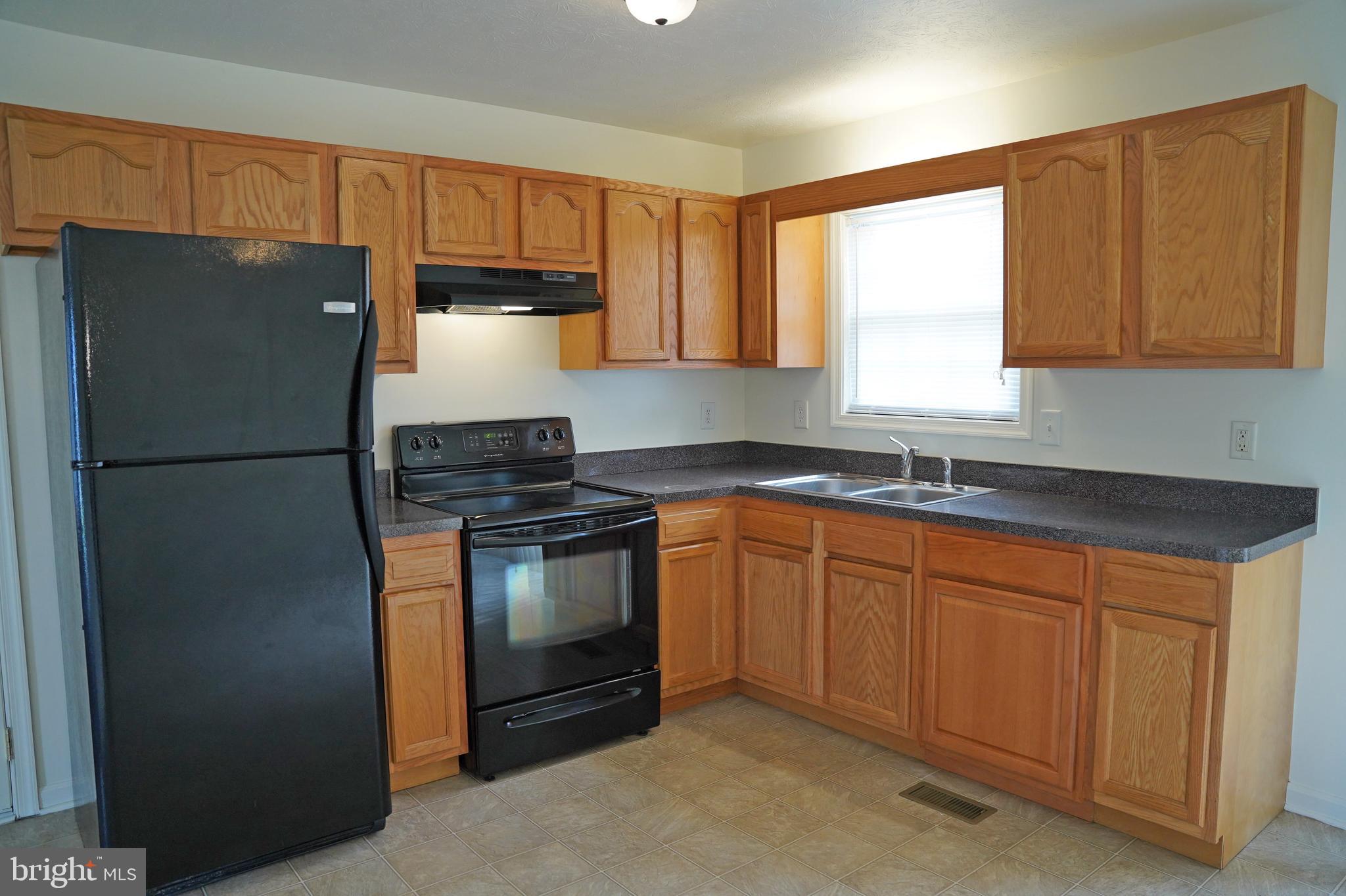122 Sinker Drive Inwood, WV 25428 - Photo 8 of 28 a kitchen with granite countertop a refrigerator stove top oven a sink and dishwasher