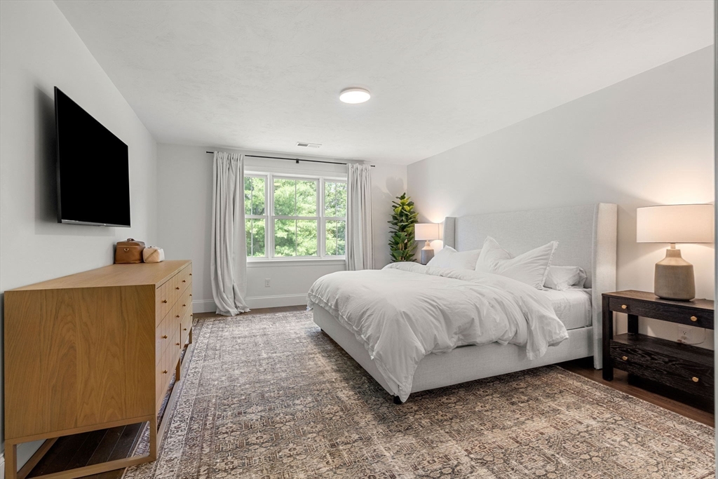 32 Cutter Lane, Unit 32 Amesbury, MA 01913 - Photo 16 of 37 a spacious bedroom with a bed and a flat screen television