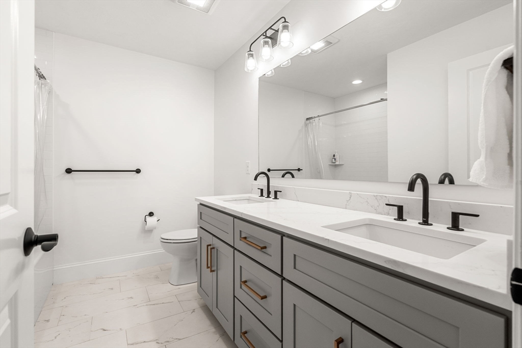 32 Cutter Lane, Unit 32 Amesbury, MA 01913 - Photo 28 of 37 a bathroom with a double vanity sink mirror and toilet