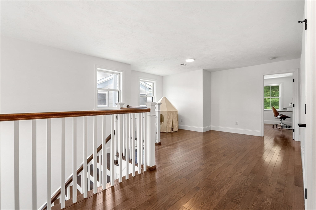 32 Cutter Lane, Unit 32 Amesbury, MA 01913 - Photo 30 of 37 a view of a hallway with wooden floor and stairs