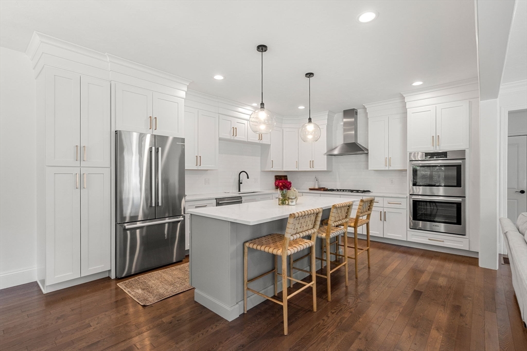 32 Cutter Lane, Unit 32 Amesbury, MA 01913 - Photo 5 of 37 a kitchen with stainless steel appliances a dining table chairs stove and refrigerator