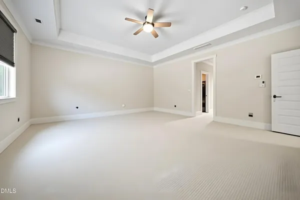 a white painted room with a window and wooden floors
