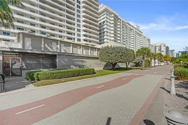 a view of a tall building next to a yard