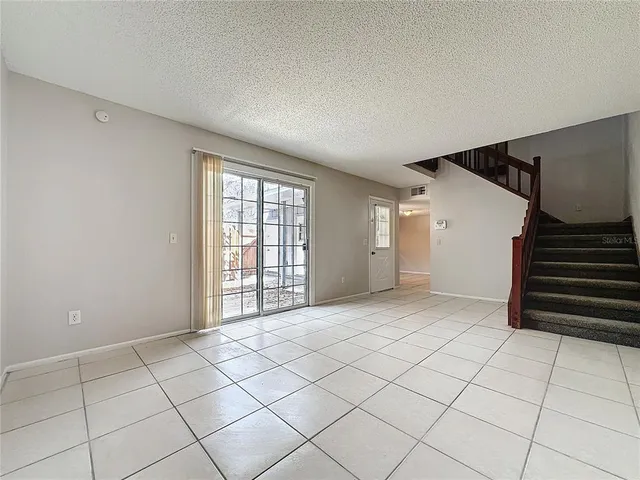 a view of an empty room with stairs and stairs