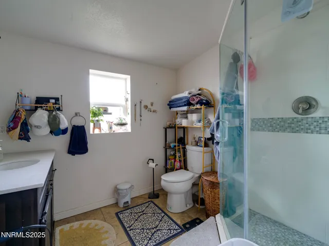 a bathroom with a granite countertop toilet sink and mirror
