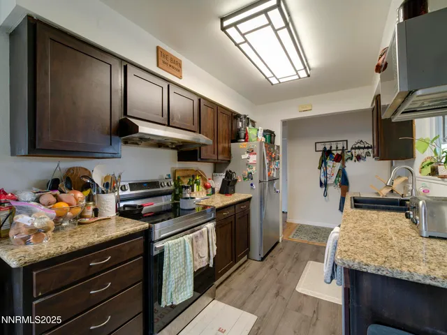 a kitchen with granite countertop lots of counter top space a sink and appliances