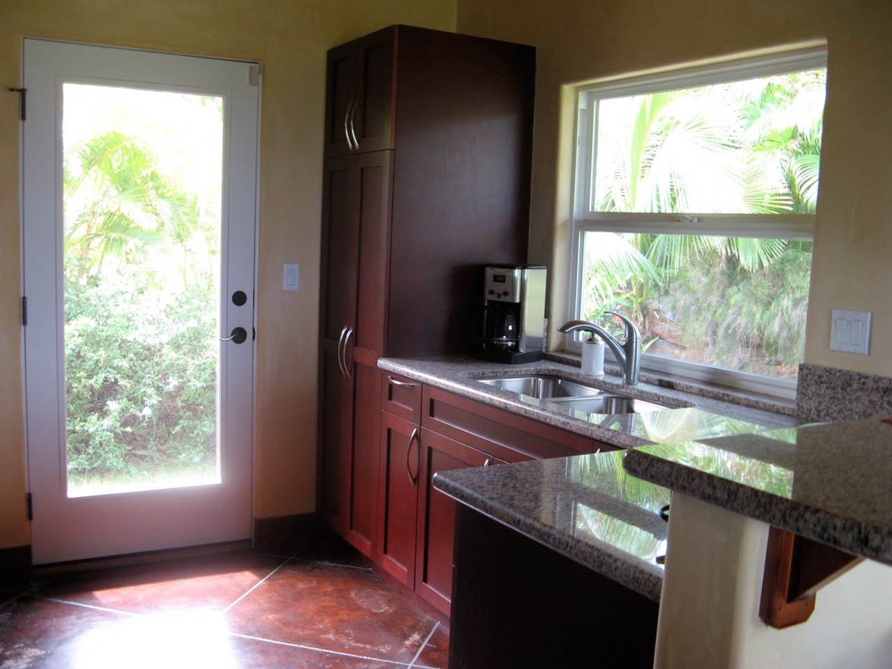 560 North Holokai Road Haiku, HI 96708 - Photo 27 of 30 a kitchen with kitchen island a sink appliances cabinets and a large window