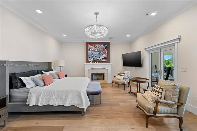 a bedroom with furniture a fireplace and a flat screen tv