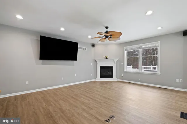 a view of an empty room with a fireplace and a window