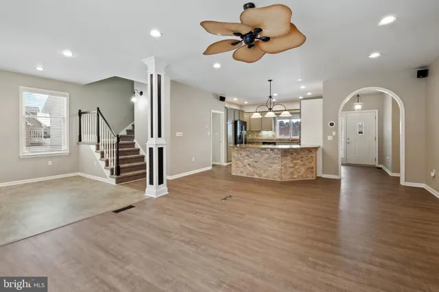 a view of a livingroom with a ceiling fan wooden floor and chandelier
