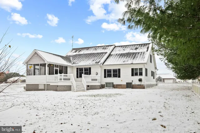 a front view of a house with a yard covered in snow