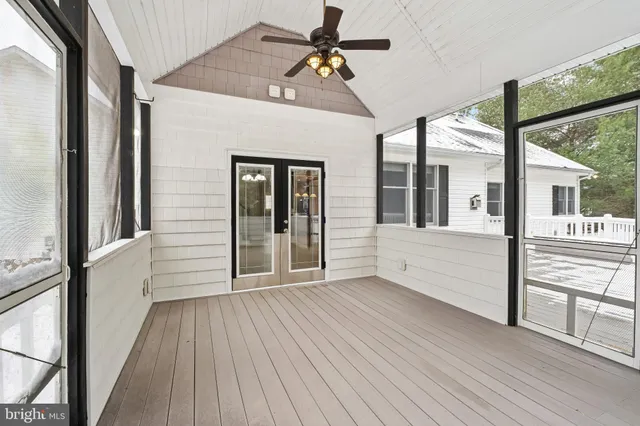 a view of a porch with wooden floor and a floor to ceiling window