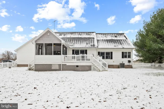 a front view of a house with a yard covered with snow