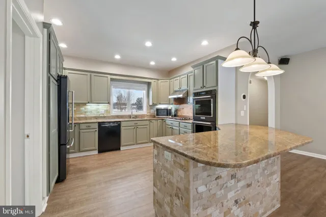 a kitchen with kitchen island a sink stainless steel appliances and counter space