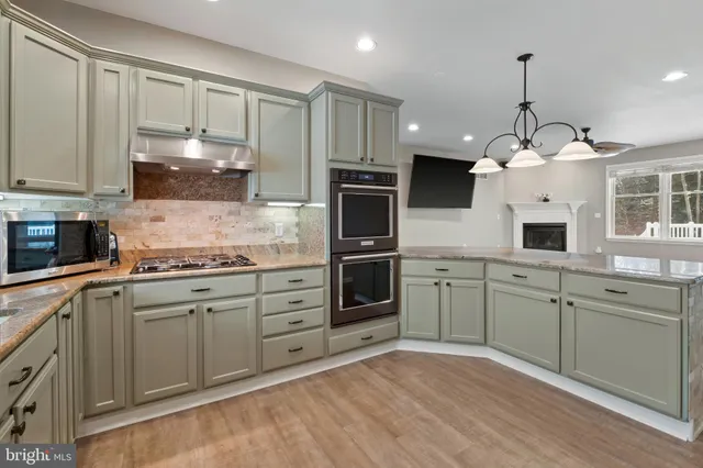 a kitchen with kitchen island granite countertop a stove a sink and a refrigerator