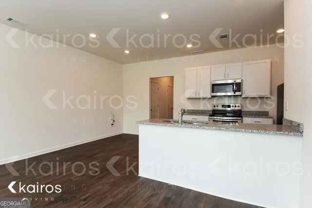 a kitchen with granite countertop a refrigerator and a stove
