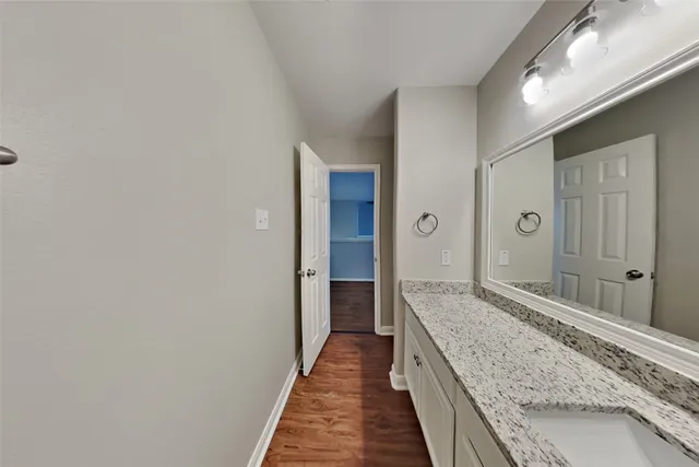 a bathroom with a granite countertop sink and a mirror