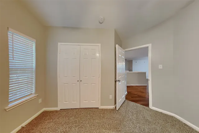 an empty room with windows and closet
