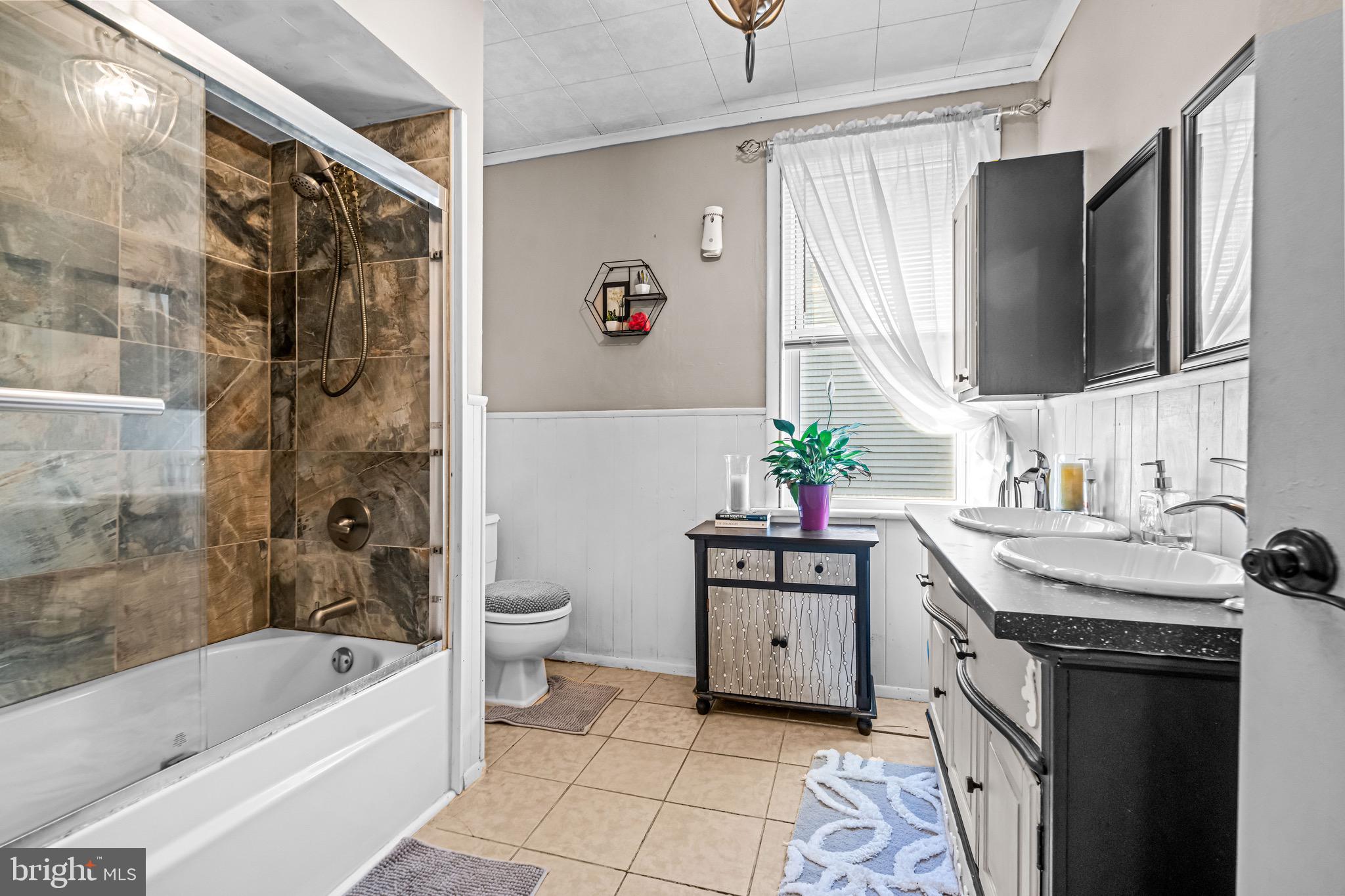 127 Cleveland Avenue Riverside, NJ 08075 - Photo 17 of 23 a bathroom with a granite countertop sink a mirror a bathtub and a shower