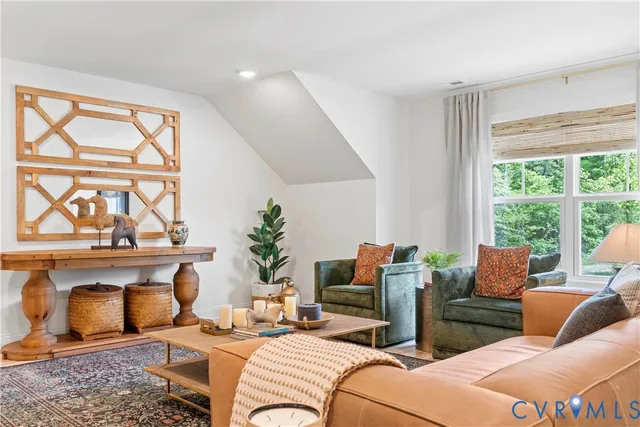 a living room with furniture a fireplace and a floor to ceiling window
