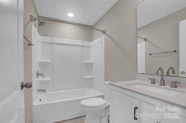 a bathroom with a granite countertop sink a toilet and shower