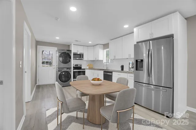 a kitchen with stainless steel appliances a refrigerator a stove a dining table and chairs