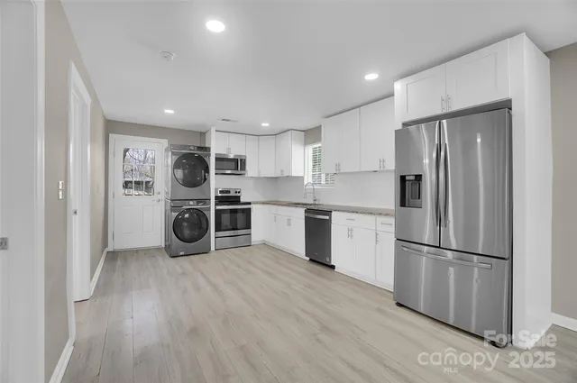 a kitchen with stainless steel appliances a refrigerator sink and cabinets