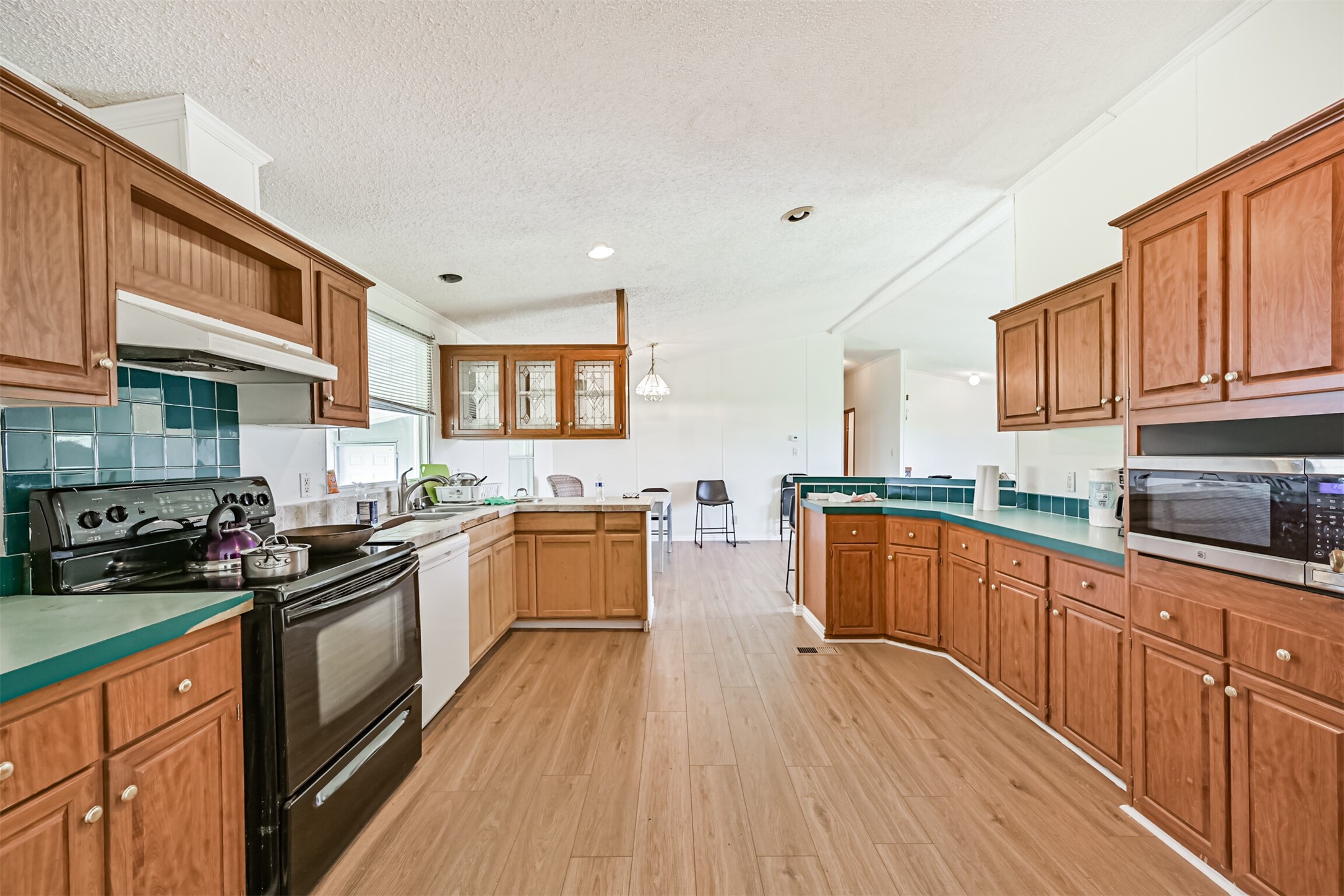 14515 Farm To Market Road 523 Angleton, TX 77515 - Photo 14 of 25 a kitchen with stainless steel appliances a stove top oven a sink dishwasher and cabinets with wooden floor