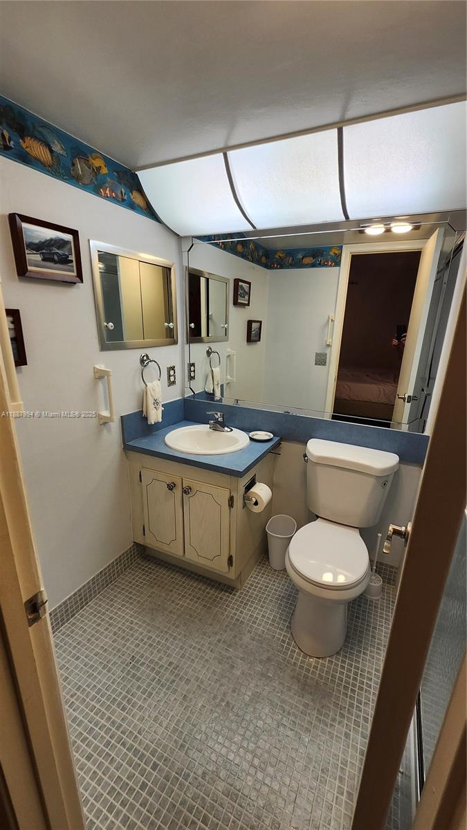 2079 Harwood F, Unit 2079 Deerfield Beach, FL 33442 - Photo 15 of 33 a bathroom with a sink toilet and mirror