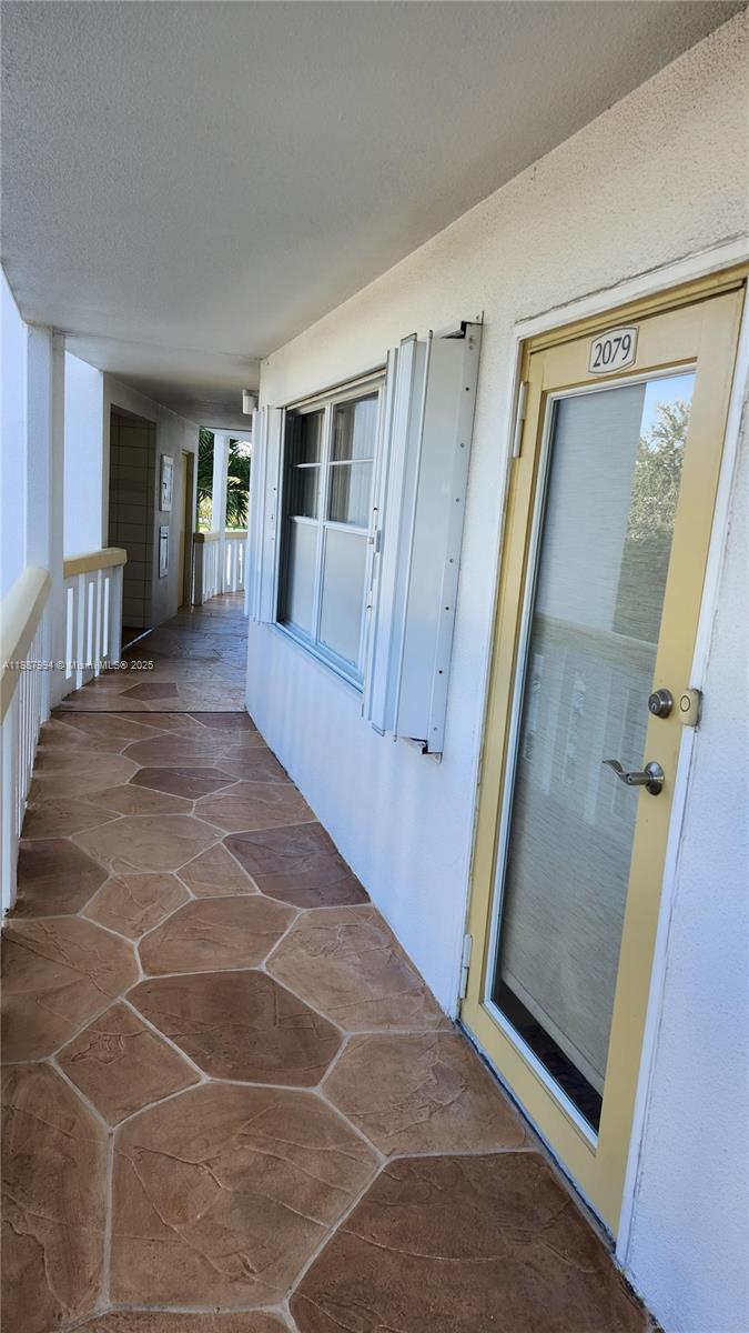 2079 Harwood F, Unit 2079 Deerfield Beach, FL 33442 - Photo 4 of 33 a view of a hallway with wooden floor and windows