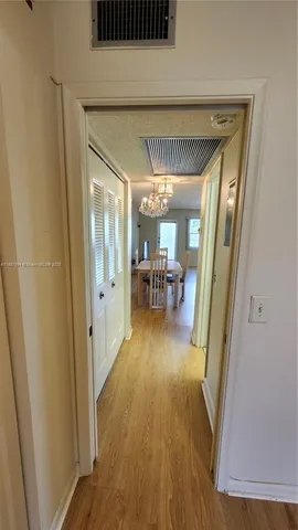a view of a hallway with furniture and wooden floor