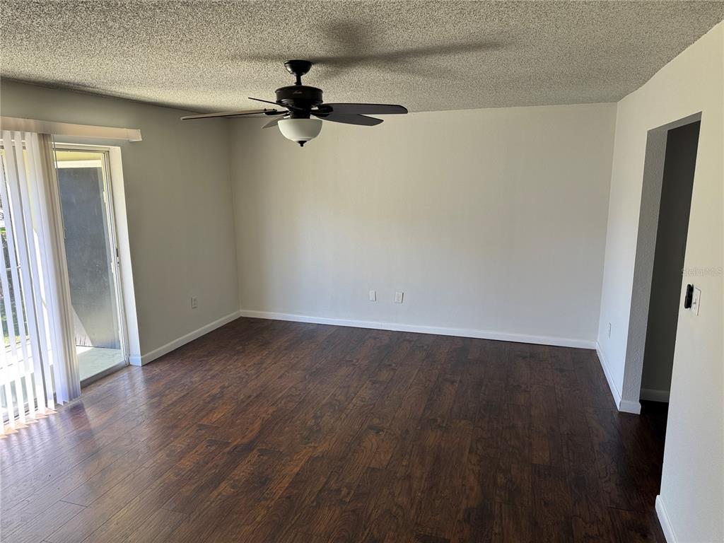 525 South Conway Road, Unit 220 Orlando, FL 32807 - Photo 3 of 12 an empty room with wooden floor cabinet and windows