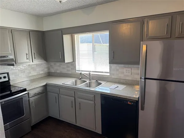 a kitchen with a sink a refrigerator and cabinets