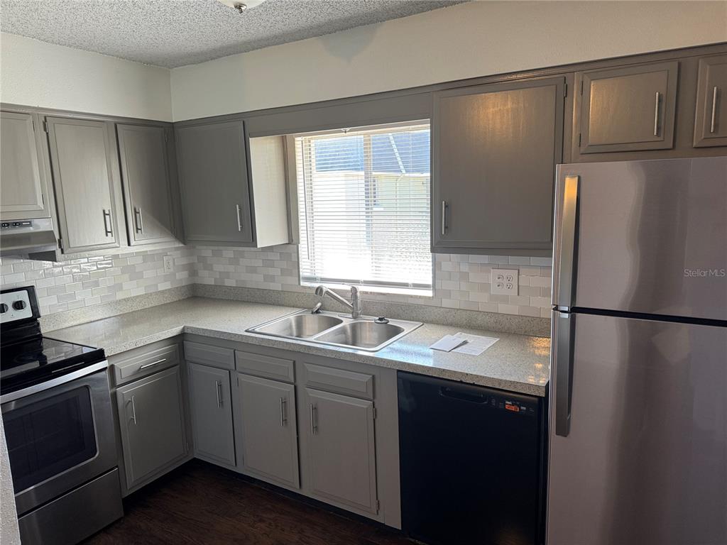 525 South Conway Road, Unit 220 Orlando, FL 32807 - Photo 6 of 12 a kitchen with a sink a refrigerator and cabinets