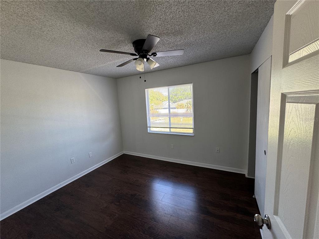 525 South Conway Road, Unit 220 Orlando, FL 32807 - Photo 10 of 12 an empty room with wooden floor fan and windows