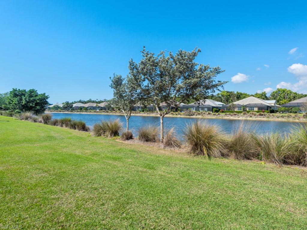 5697 Highbourne Drive Naples, FL 34113 - Photo 24 of 35 a front view of a house with a yard and lake view