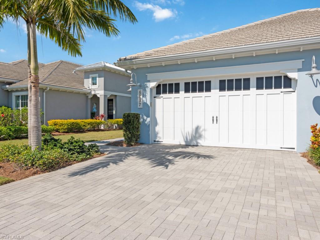 5697 Highbourne Drive Naples, FL 34113 - Photo 26 of 35 a front view of a house with a yard and garage