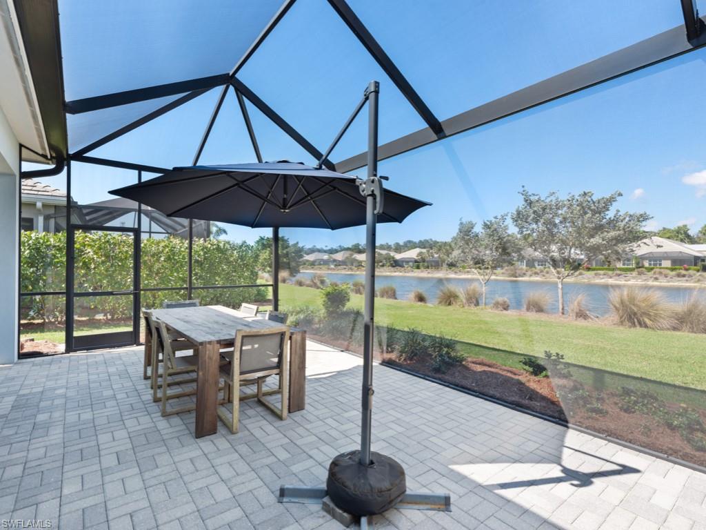 5697 Highbourne Drive Naples, FL 34113 - Photo 5 of 35 a view of a patio with chairs and a umbrella