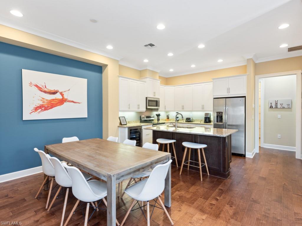 5697 Highbourne Drive Naples, FL 34113 - Photo 9 of 35 a kitchen with a dining table chairs and refrigerator