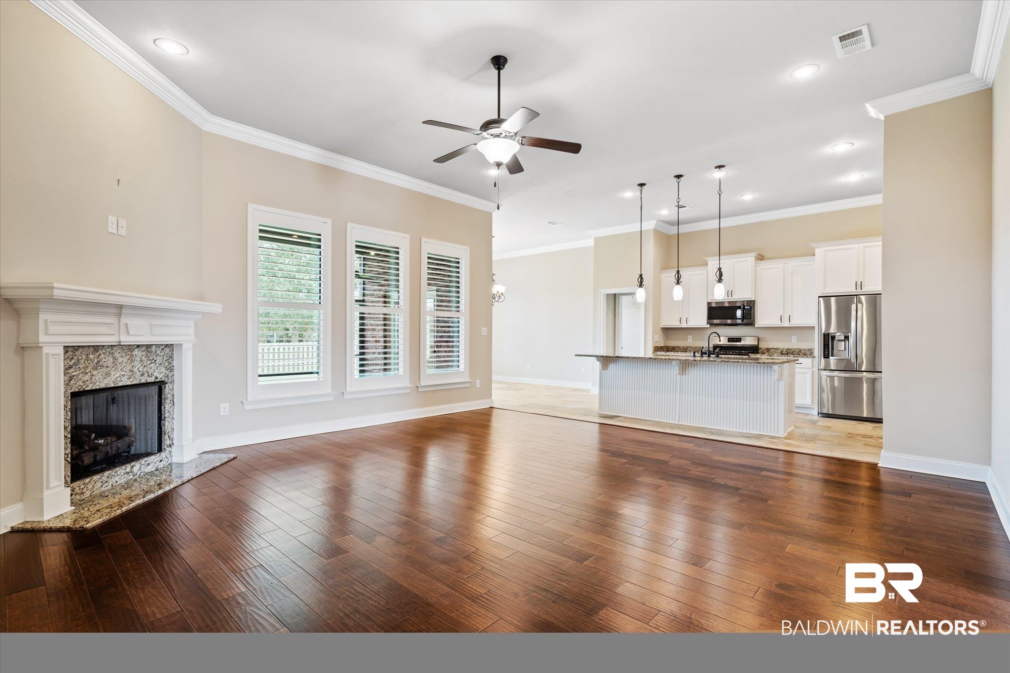 423 Breckin Drive Fairhope, AL 36532 - Photo 3 of 31 Unfurnished living room featuring crown molding, a premium fireplace, ceiling fan, and hardwood / wood-style floors