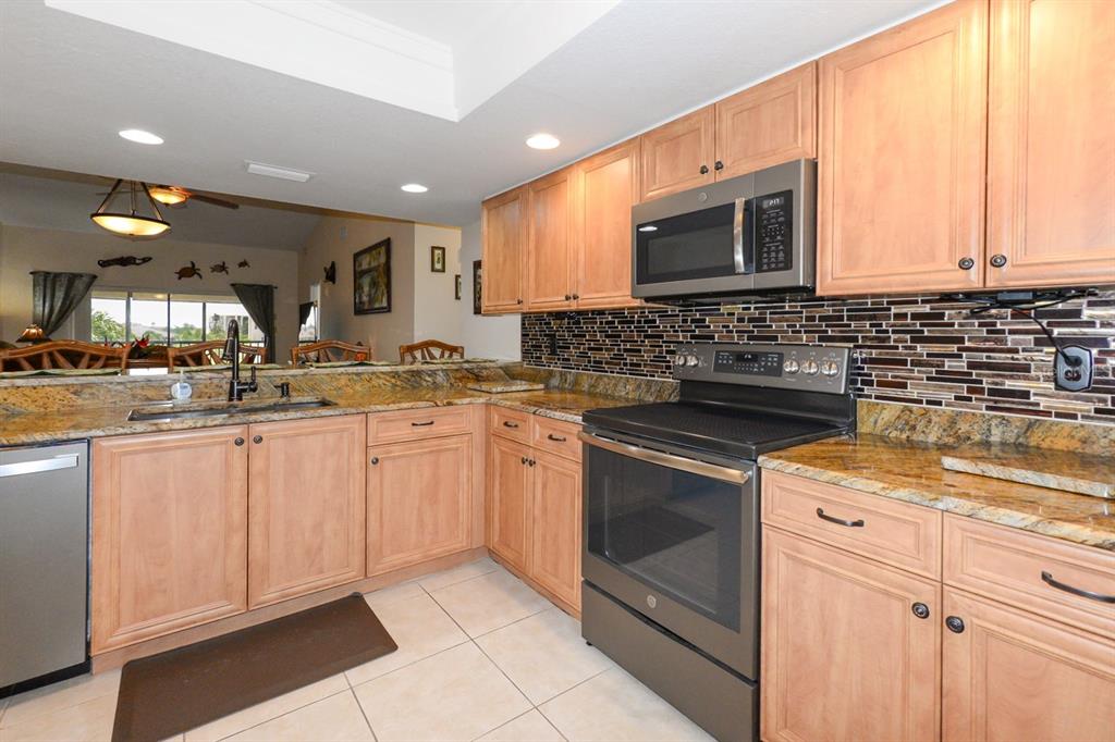 335 Coldeway Drive, Unit F21 Punta Gorda, FL 33950 - Photo 7 of 45 a kitchen with stainless steel appliances granite countertop a sink stove and microwave