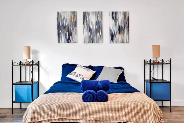 a bedroom with a bed and painting on the wall