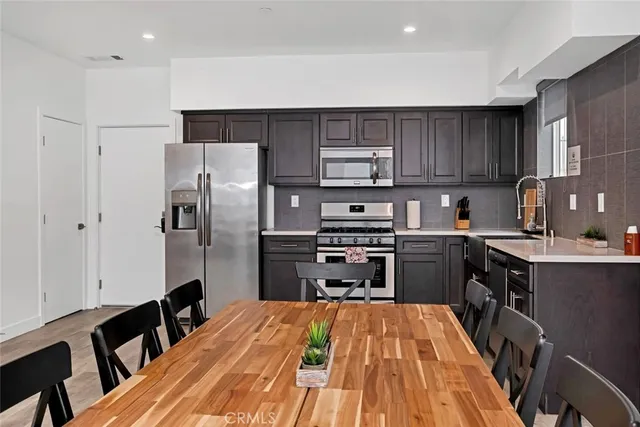 a kitchen with granite countertop a refrigerator stove top oven and sink