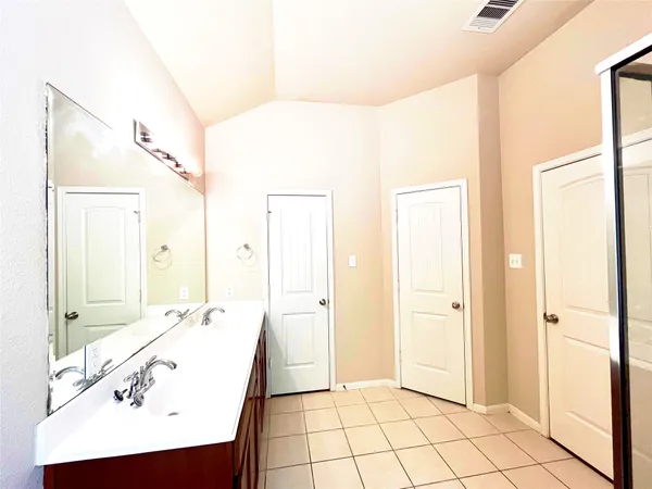 a bathroom with a tub a sink and glass door