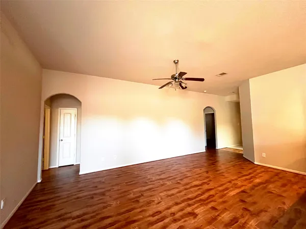 a view of a kitchen with kitchen island a stove a sink cabinetry and entryway